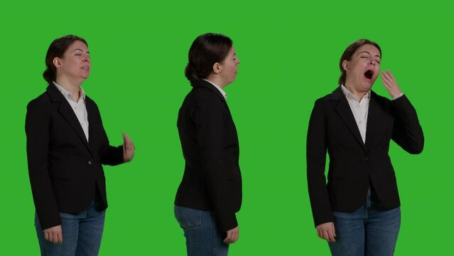 Close up of tired employee yawning and feeling fatigued on camera, acting sleepy over greenscreen background. Company employee being exhausted and falling asleep on full body green screen.