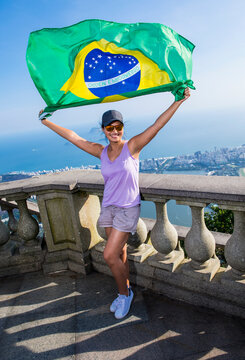 Woman holding Brazilian flag above Rio de Janeiro