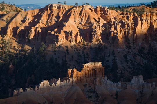 Sunset light selectively illuminates colorful sandstone hoodoos in Bryce Canyon National Park, Utah.