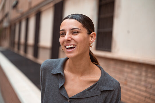 Young woman smiling, looking one side in the street
