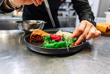 chef hand preparing Meat Pie with mashed potato and salad on restaurant kitchen