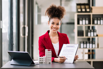 Real estate broker agent presenting and consult to customer to decision making sign insurance form agreement, home model, concerning mortgage loan offer in office.