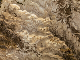 Overhead aerial shot of a yellowish moonscape in remote location desert area. Golden hour sunset view.