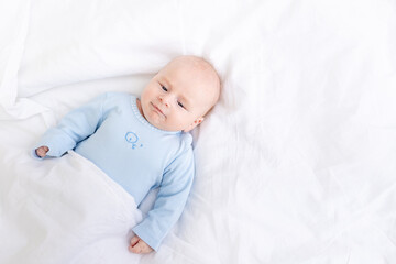 morning baby boy on the bed under the blanket, healthy newborn sleep