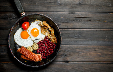 Traditional English Breakfast with fried eggs, sausages and beans.