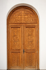 Wooden door engraved with religious and floral motifs at Dumbrava monastery - Romania
