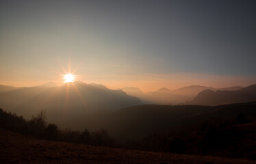 Landscape with the ridges of the Apuseni mountains - Romania in a foggy evening