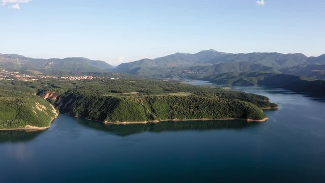 A panoramic view of a stunning, calm lake with mountains in the distance near Debar, Macedonia