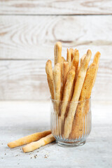 Grissini with herbs on a gray concrete background