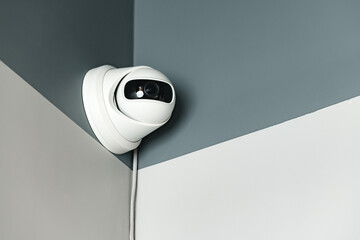 CCTV camera on gray wall close up