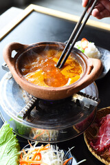 Traditional korean hot pot dish with beef and spicy bouillon on black table