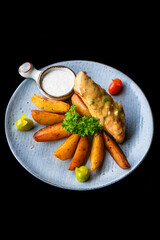 Chicken chop steak with french fries on blue plate isolated on black background side view