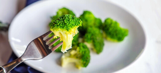 Close-up of green fresh vegetable broccoli. Fresh green broccoli on plate. Broccoli vegetable is full of health. Vegetables for diet and healthy eating.Top view