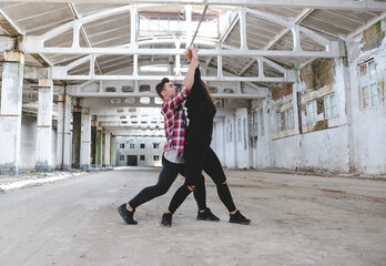 Boy and girl dancing hip-hop in old industrial building. Young couple training dance positions. Street urban lifestyle.