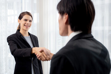 Happy business man and woman standing and shake hands while agreement of negotiation success and congratulations at office, businessman and partner handshake while greeting together, business concept.