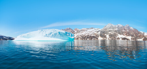 Melting icebergs by the coast of Greenland, on a beautiful summer day - Melting of a iceberg and pouring water into the sea - Greenland