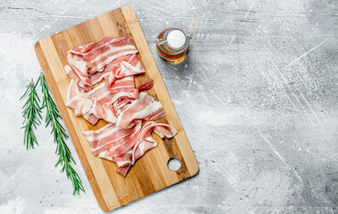 Raw bacon with rosemary and olive oil.