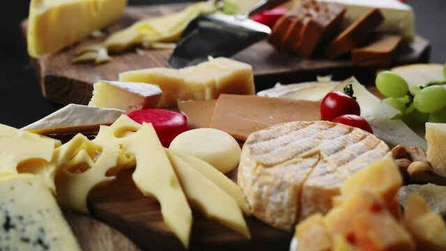 Cheese plate with various cheeses on a dark table.