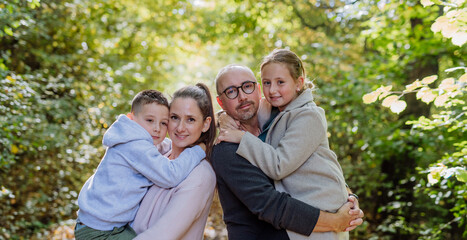 Portrait of happy family with kids in a forest.