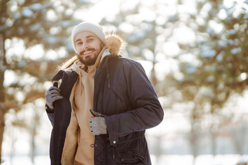 Young man in snowy winter forest. People, lifestyle, relaxation and vacations concept.