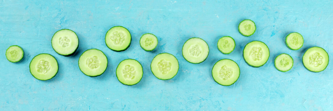 Fresh Cucumber Slices On A Blue Background Panorama, Overhead Flat Lay Shot. Healthy Organic Food Panoramic Banner