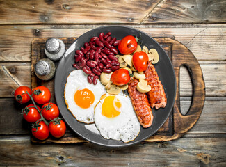 English breakfast.Fried eggs with sausages, mushrooms and beans.