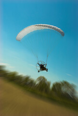 Paraglider flying in motion blur