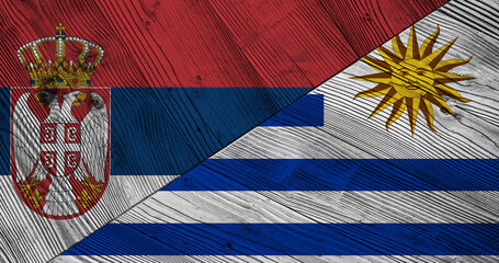 Background with flag of Serbia and Uruguay on wooden divided table. 3d illustration