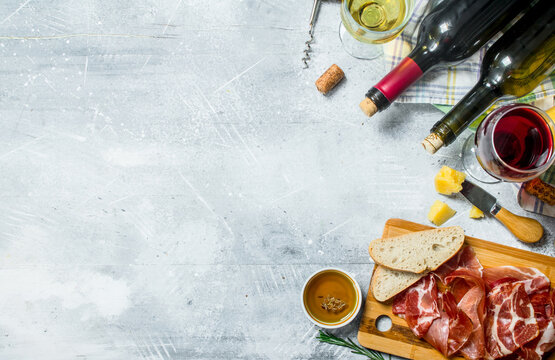Antipasto background. Red and white wine with meat and cheese appetizers.
