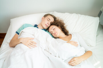 Obraz na płótnie Canvas Lovely couple sleeping on white bed morning scene