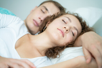 Obraz na płótnie Canvas Lovely couple sleeping on white bed morning scene
