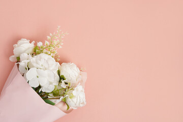 Wedding flowers, bridal bouquet. White roses and decorative plants on pink background