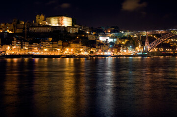 Fototapeta na wymiar Night scene, Porto Portugal, with reflections in the river Douro.