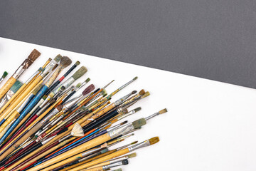Obraz premium Many brushes for painting on a colored background, top view.