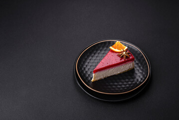 Delicious sweet cheesecake with raspberry jam on a black ceramic plate