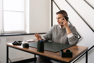 mature business woman talking on a mobile phone while sitting at the workplace in the office