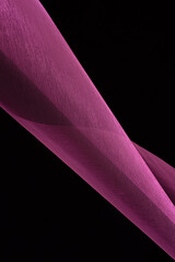 Abstract background. Swirling roll of pink satin fabric.Selective focus.