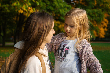 Mom and preschool daughter walking in the park