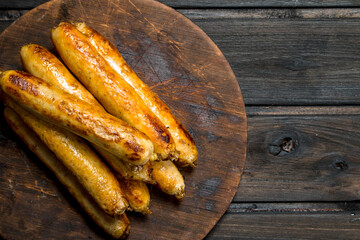 Grill beef sausages on a round Board.