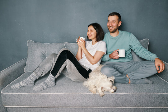 Happy smiling couple drinking coffee relaxing on couch