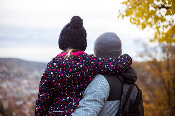 Young man and child girl standing with their backs looking at the panoramic view