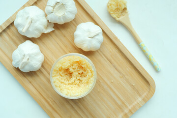 close up of minced garlic on a wooden spoon 