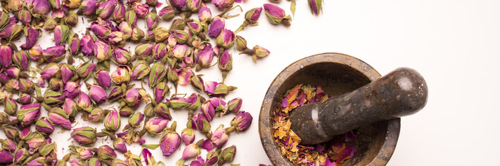 Dried damask roses for natural herbal cosmetics. With mortar for preparation.