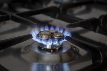 Burning natural gas and british coins on gas hob. The concept of the struggle for global gas...