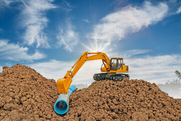 Crawler excavators digging water pipes at construction site . on clouds sky and sunbeam backgrounds.