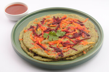 Pesarrattu or green dosa made from green moong dal and rice, garnished with grated beetroot and carrot, a healthy south Indian dosa