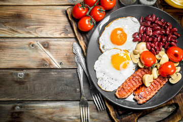 English breakfast.Fried eggs with sausages, mushrooms and beans.