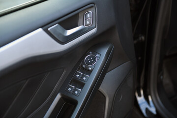 Obraz na płótnie Canvas Close-up of side door buttons: window adjustment buttons, door lock. modern car interior: details, buttons, knobs