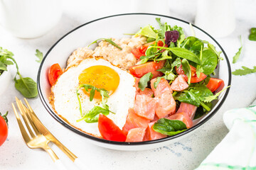 Savory breakfast. Oatmeal porrige with salted salmon, egg and fresh salad. Healthy food, balanced nutrition.