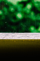 Cinematic shot of raindrops falling from the grey skies and onto the wet surface of a balcony...